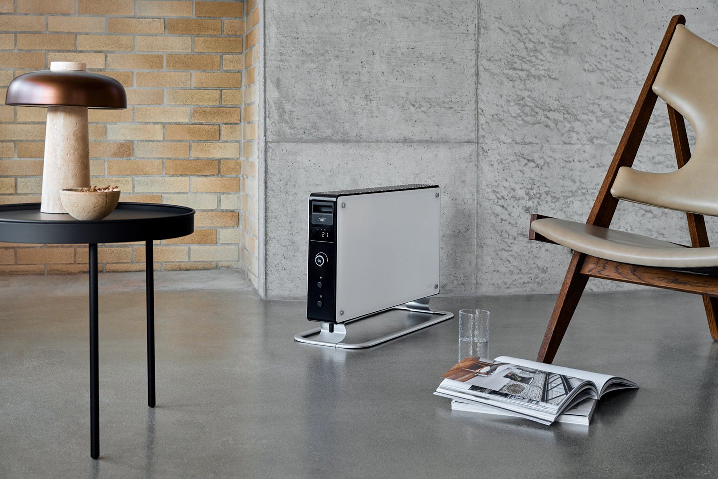 Fokus på hvit mill gulvovn i en stue med steinvegger.