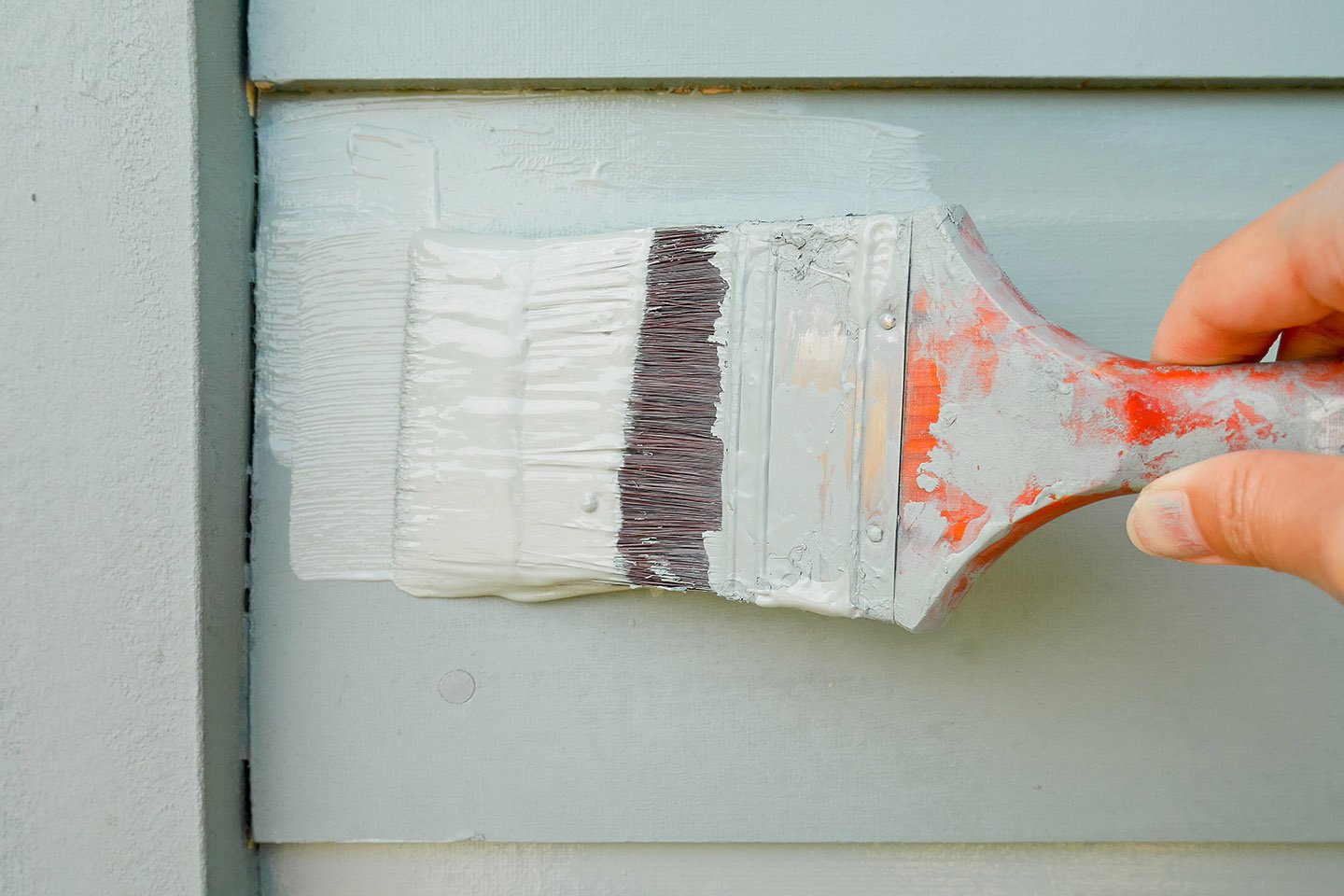 Veggen som blir malt med malepensel.