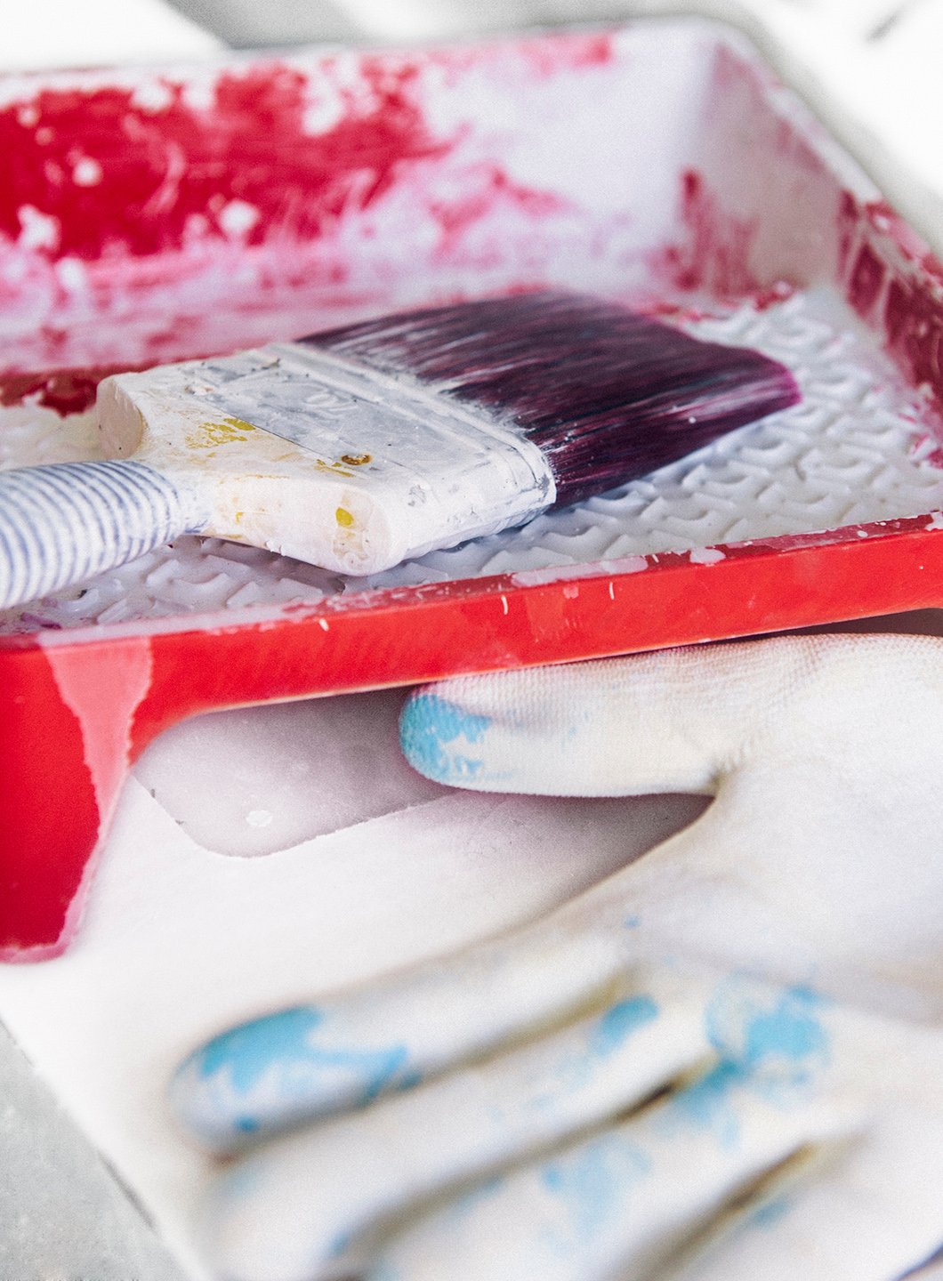 Malerull og hansker liggende på malebrett med hvit maling