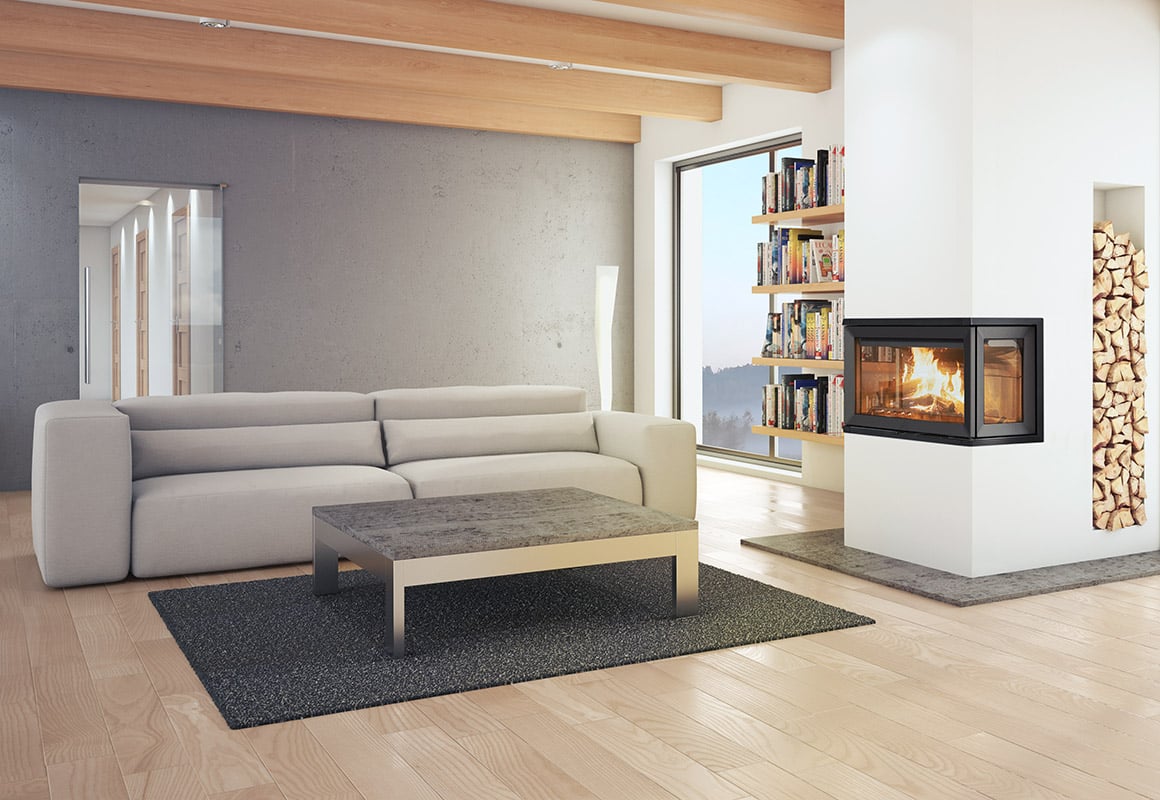 Lys stue med sofa, bokhylle og ny rentbrennende vedovn plassert i hjørnet.
