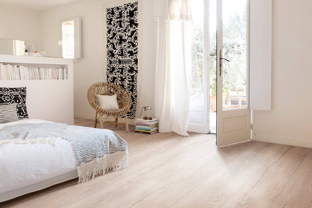 Moderne soverom med hvite vegger og lys laminatgulv