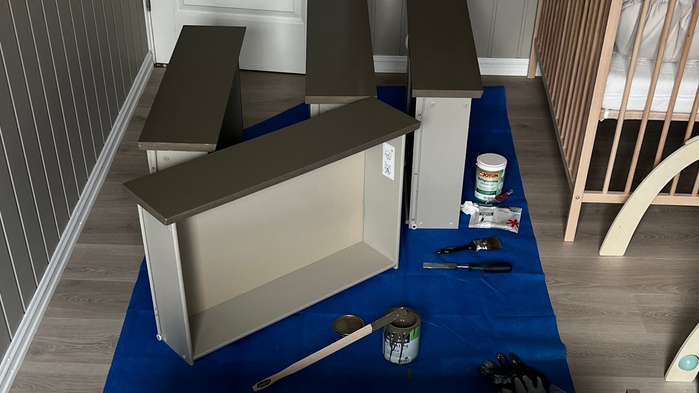 Skuffer malt i brungrå farge, tørker på gulvet.