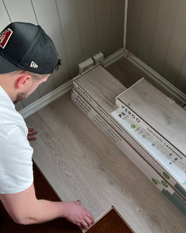 Mann som legger laminatgulv