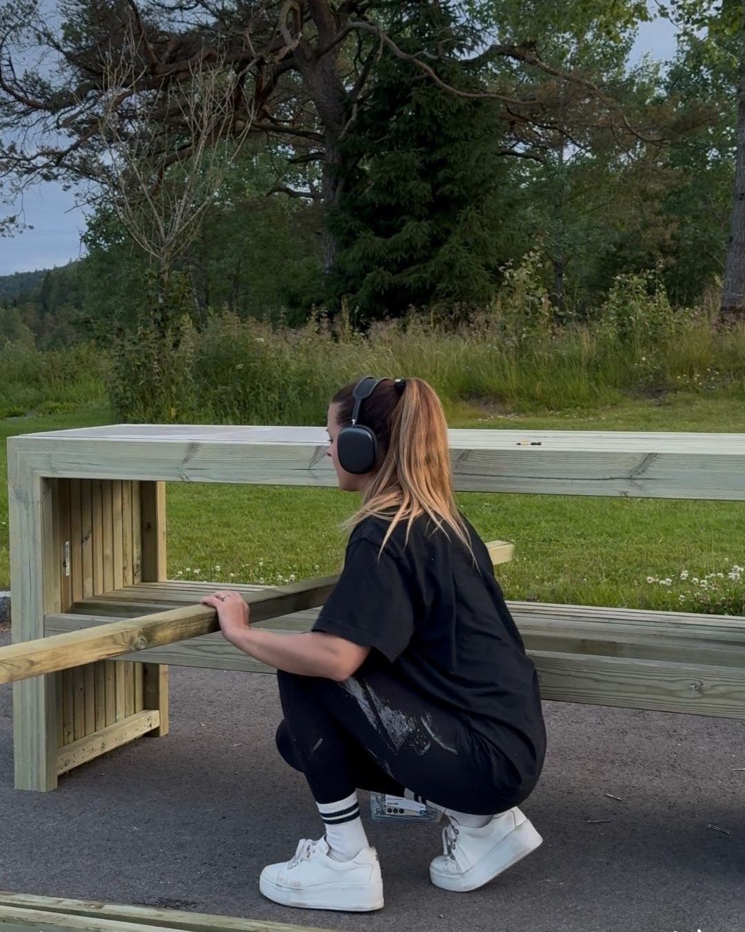 En kvinne som fyller på lekter på hyllen på benken. 