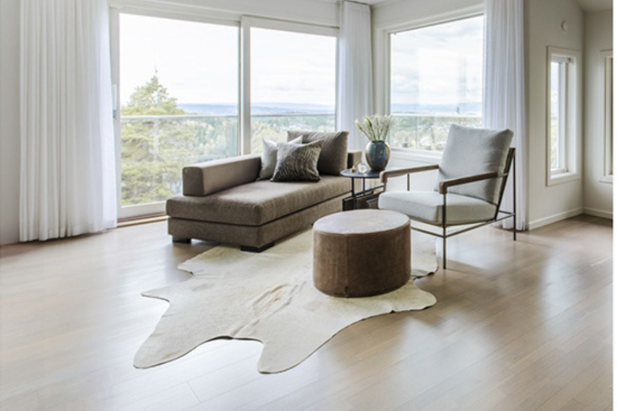 Lys og moderne stue med fornyet gulv i naturlig, matt finish og store vinduer med utsikt.