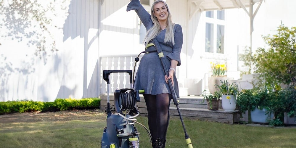 Therese Lien med AVA høytrykkspyler foran hvit hus