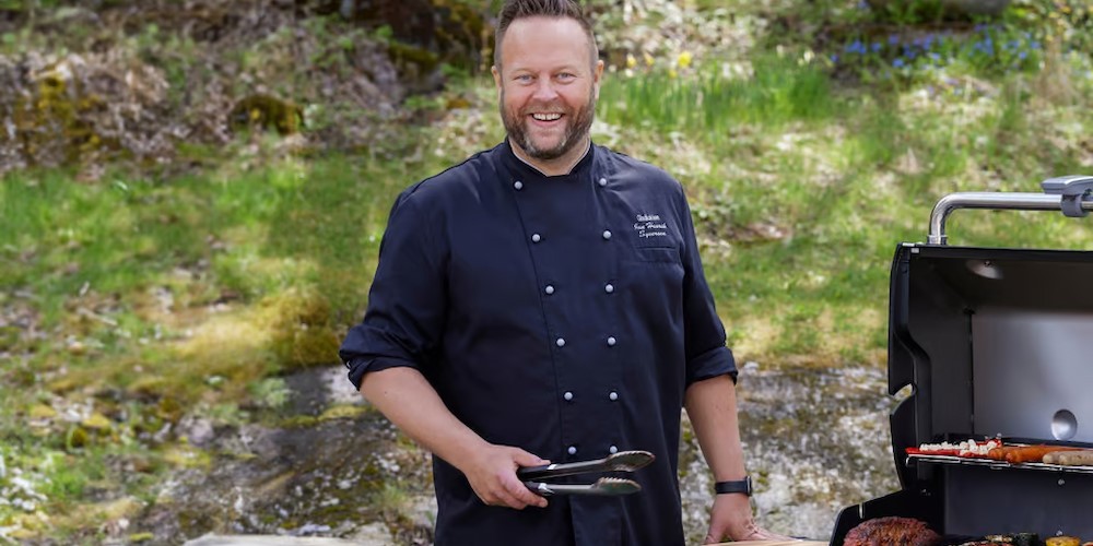 Gladkokken står foran grill