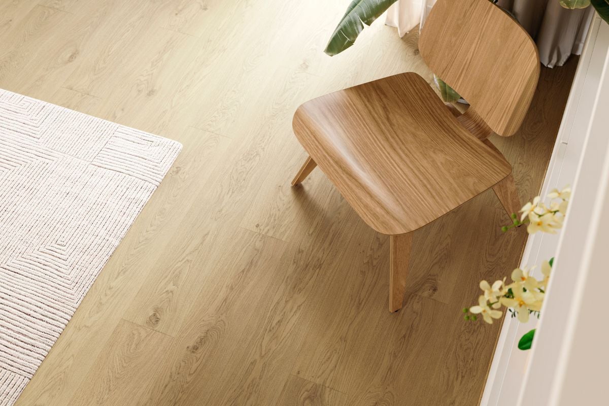 Laminatgulv i varm eik med trestol og naturinspirert interiør i lyse, harmoniske toner.