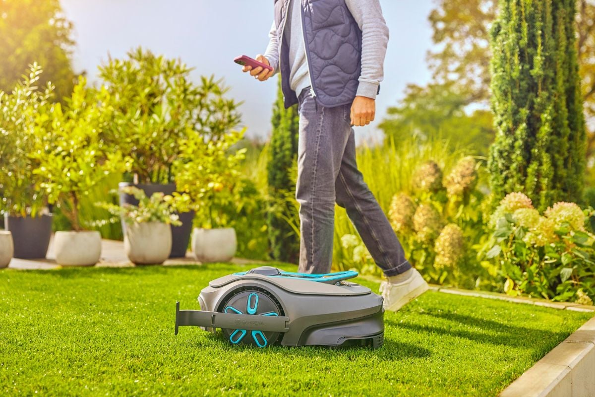 Gardena Sileno robotklipper med mann og hage i bakgrunnen