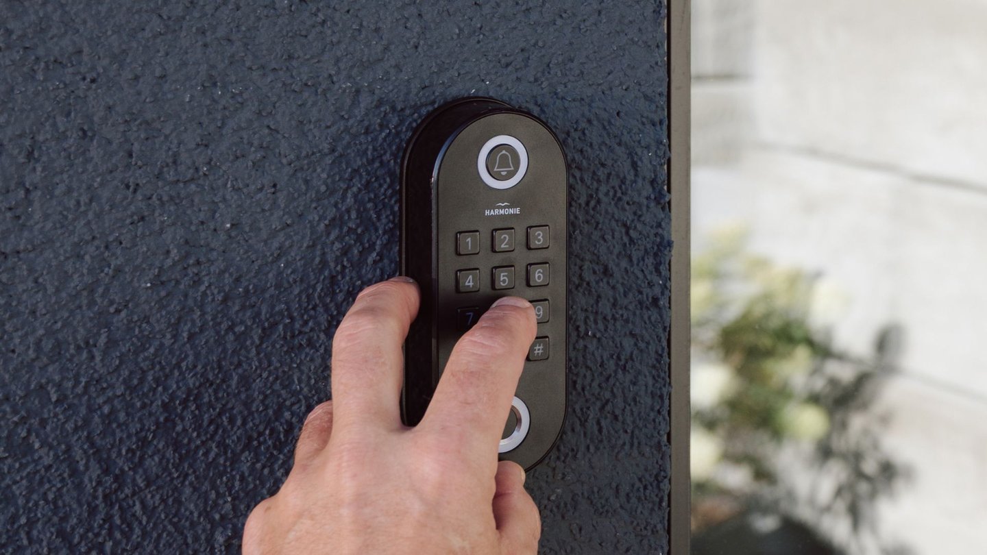 Hånd taster inn kode på et elektronisk kodelås-system fra Harmonie.