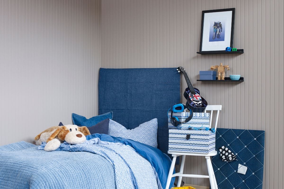 Jordfarget soveromsvegger med blått sengetøy og sengegavl
