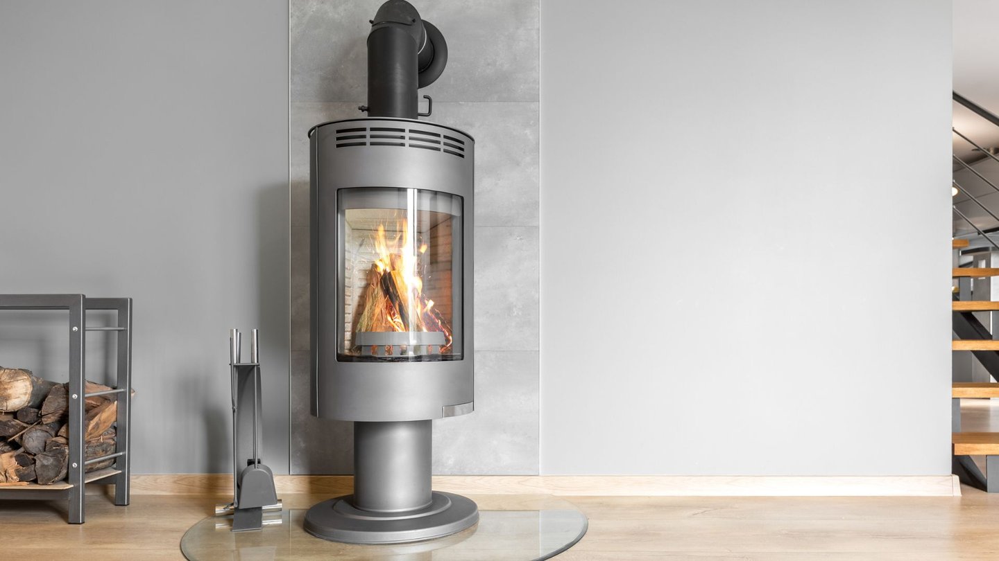 Frittstående vedovn med glassplate og synlig røykrør.