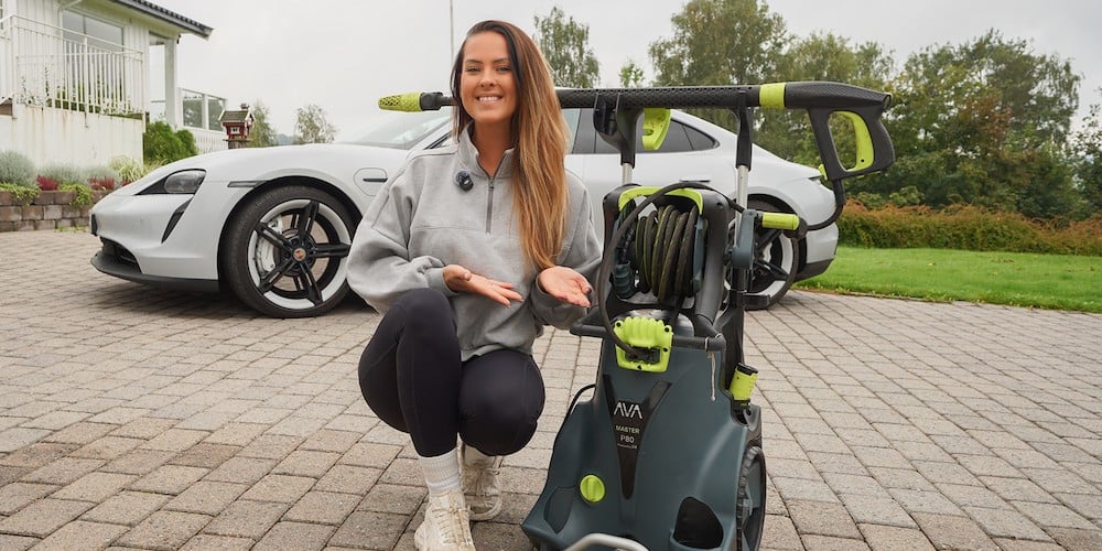 Stine Skolie presenterer AVA høytrykkspyler foran bil