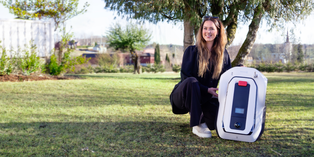 Stine Skolie poserer med robotklipper på plen