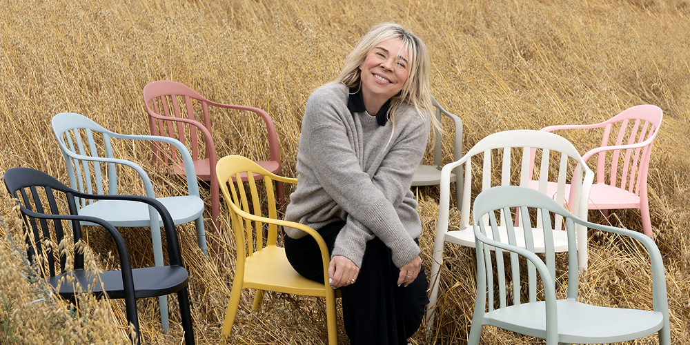 Tone Kroken sitter i eng med flerfargede Vika stoler