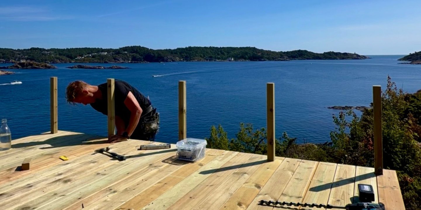 Mann fester stolper på ny platting ved havet