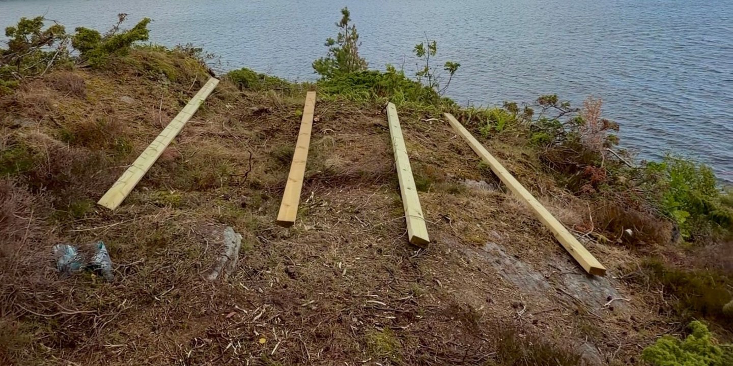 Fire planker på rekke og rad på svaberget