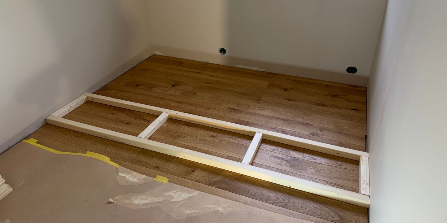 Første steg av fremgangsmåten. Her ligger grunnrammen for sengen på gulvet.