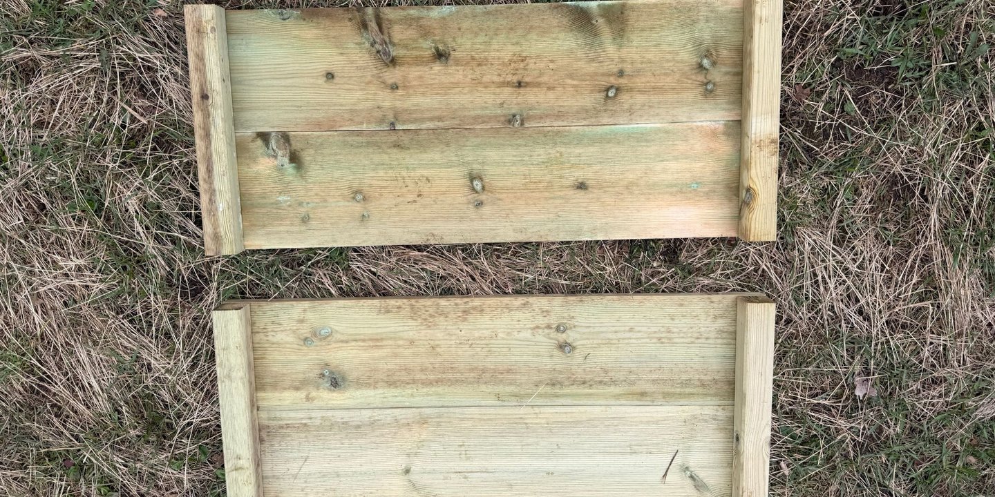 To sideplater av tre ligger på gresset