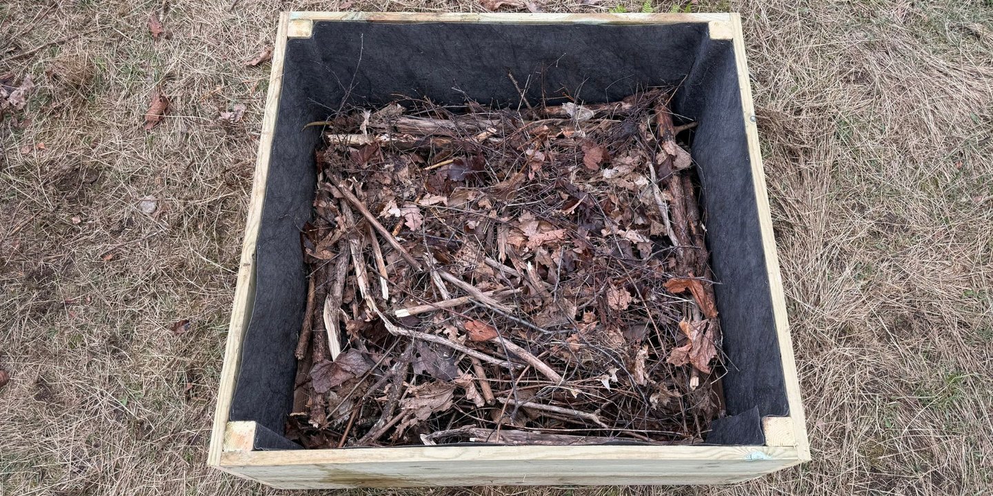 Nybygd pallekarm med fiberduk på sidene og jord i bunnen.