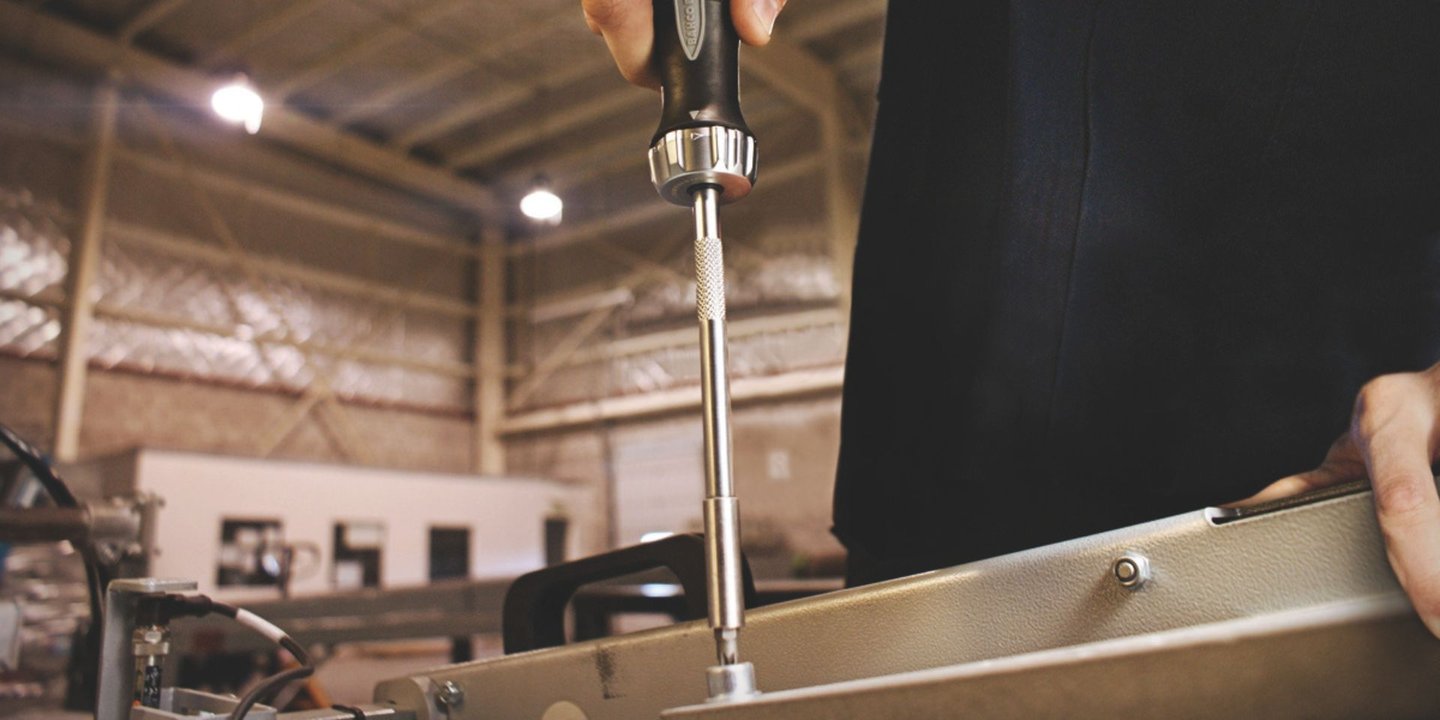 Person bruker en BAHCO skrutrekker til å skru i metalloverflate.