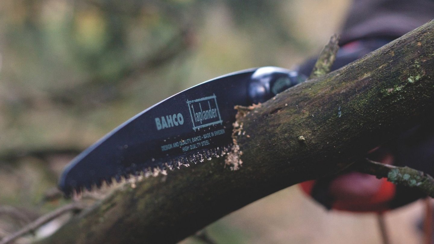 Bahco tursag som kutter i en tykk gren.