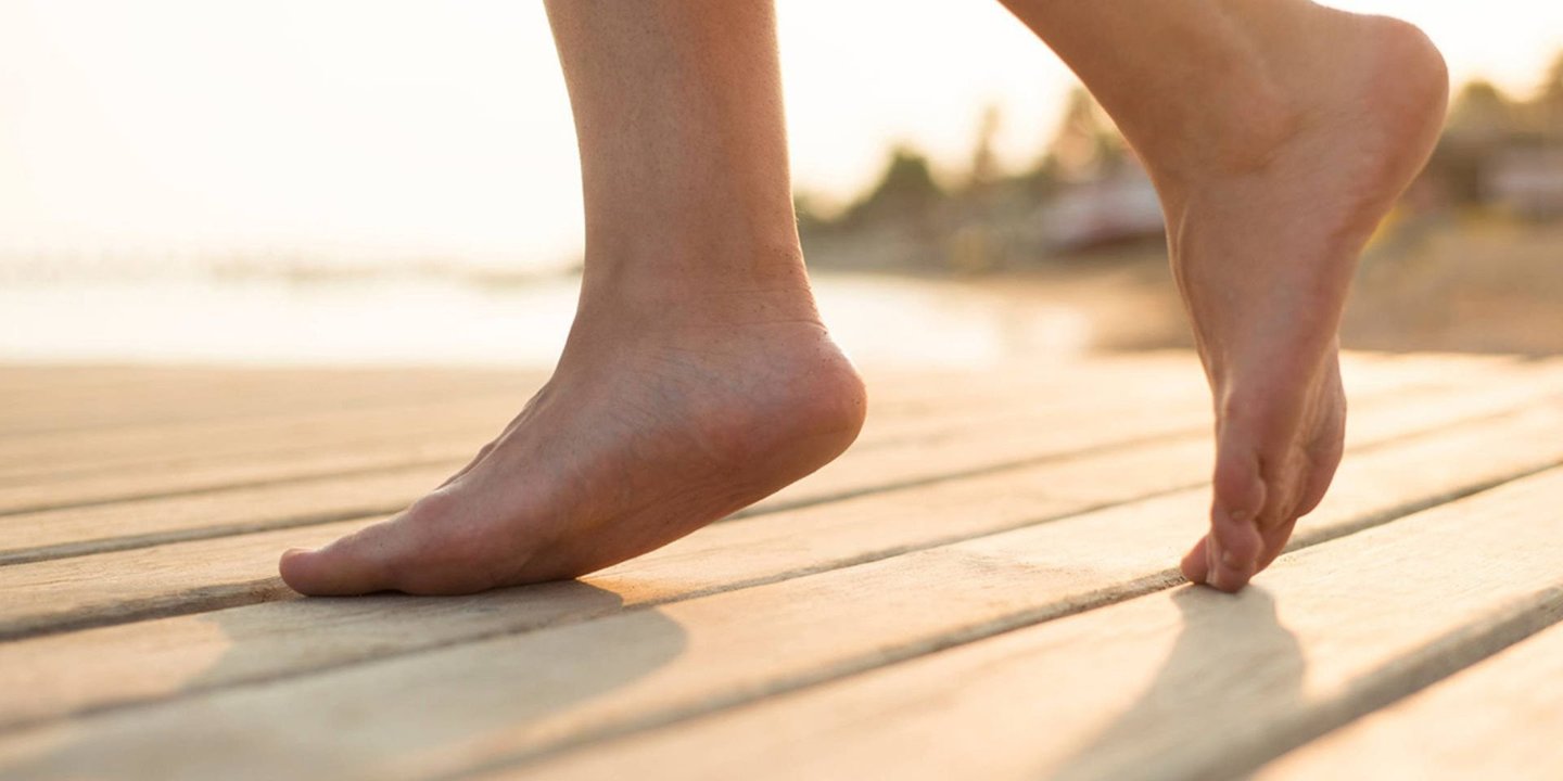 Barbeinte føtter som går på en terrasse