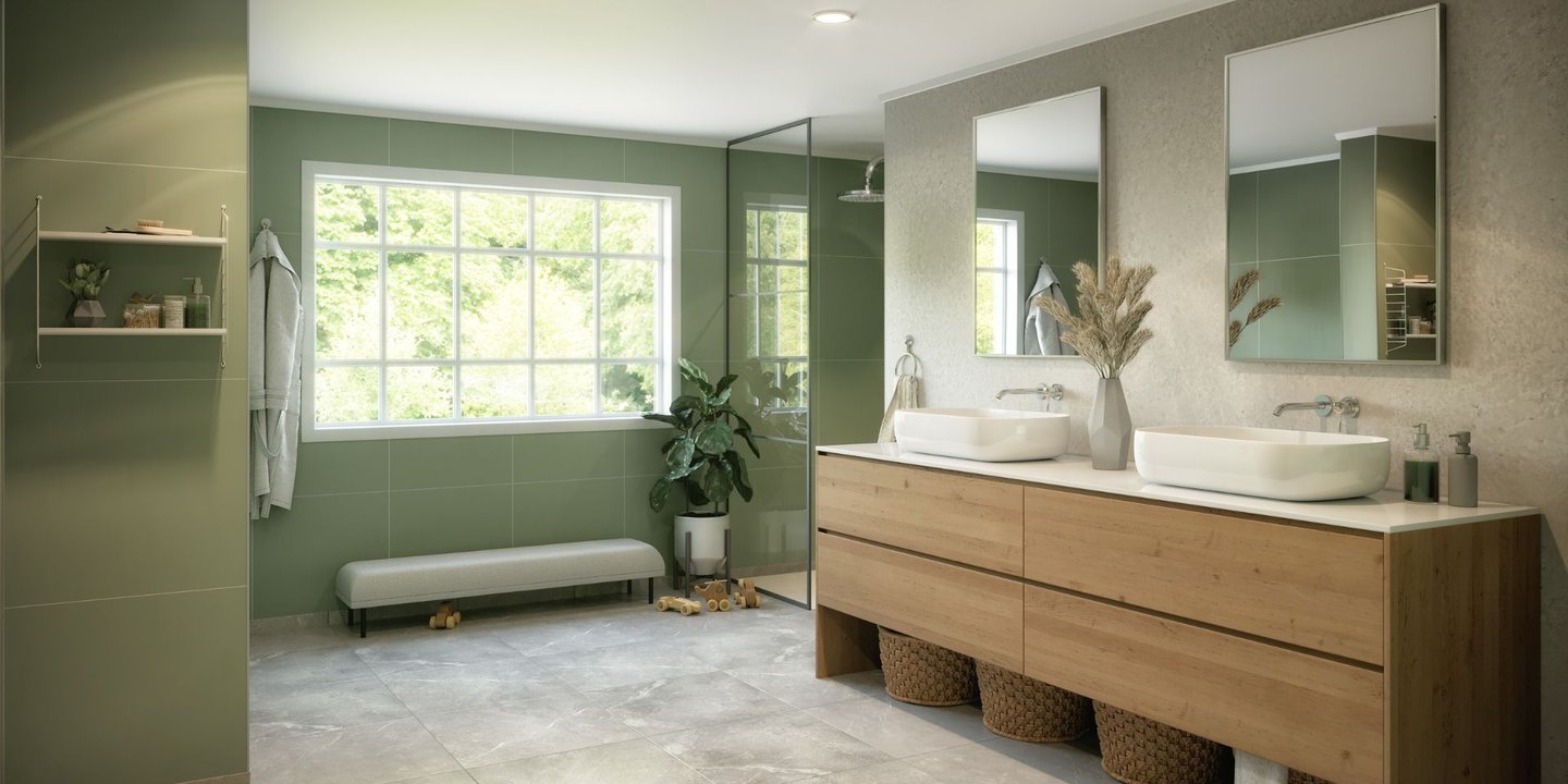 Et bad med grønne vegger og vask og skap i tre