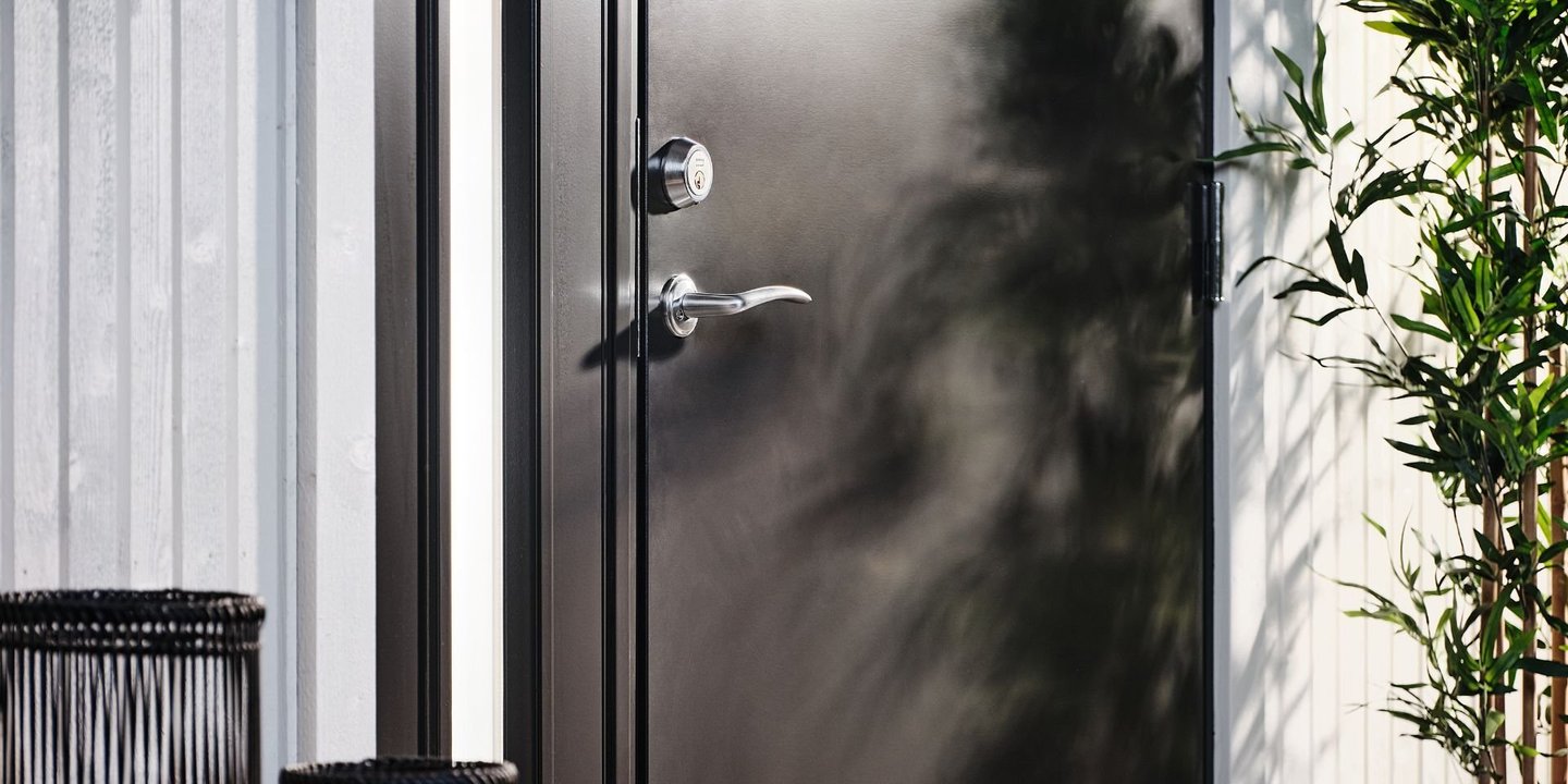 Svart dør med lykter foran seg.