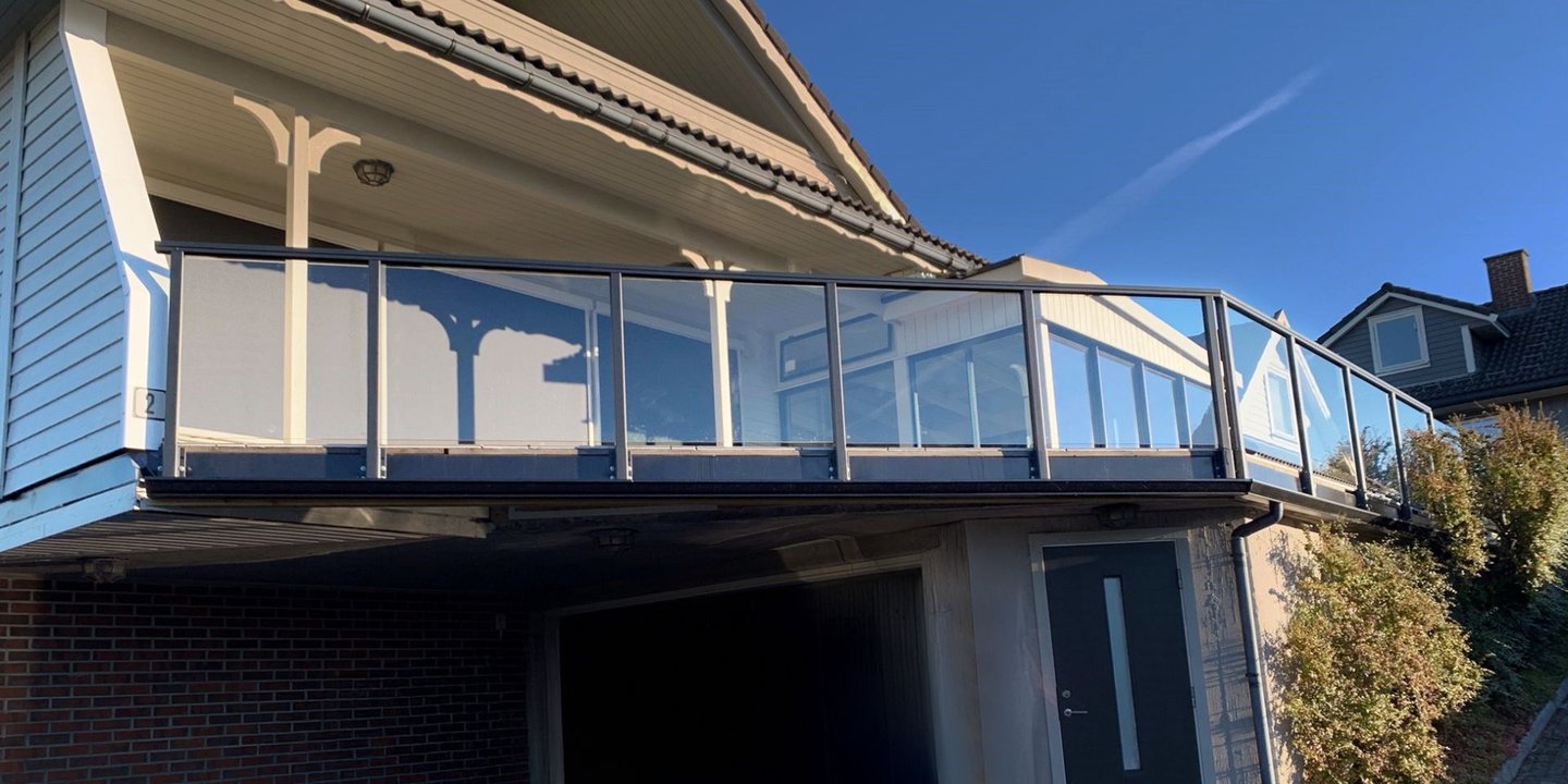 Et hvitt hus, med glassrekkverk.