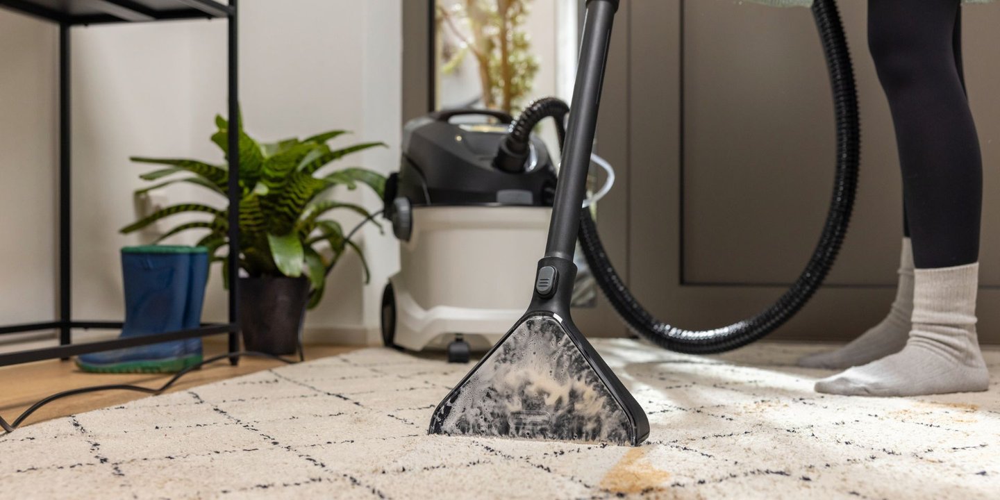 Tekstilrenser fra Kärcher som fjerner flekker på et teppe i gangen