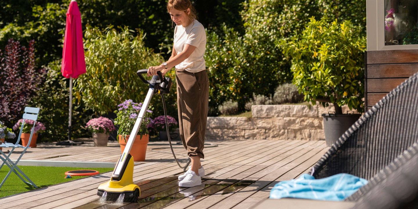 Dame bruker produkt fra Kärcher til å vaske terrassen