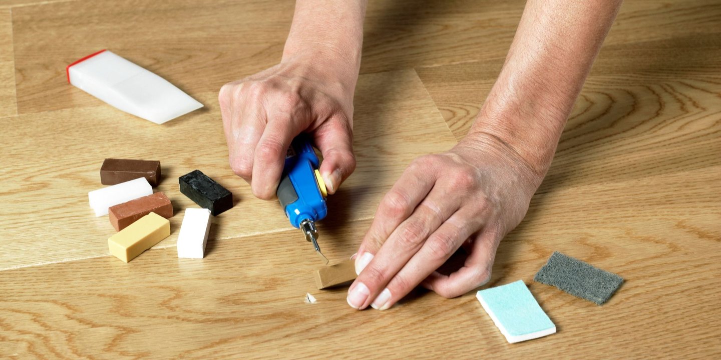 Reparer småskader i parketten enkelt med reparasjonsvoks og smelteverktøy.