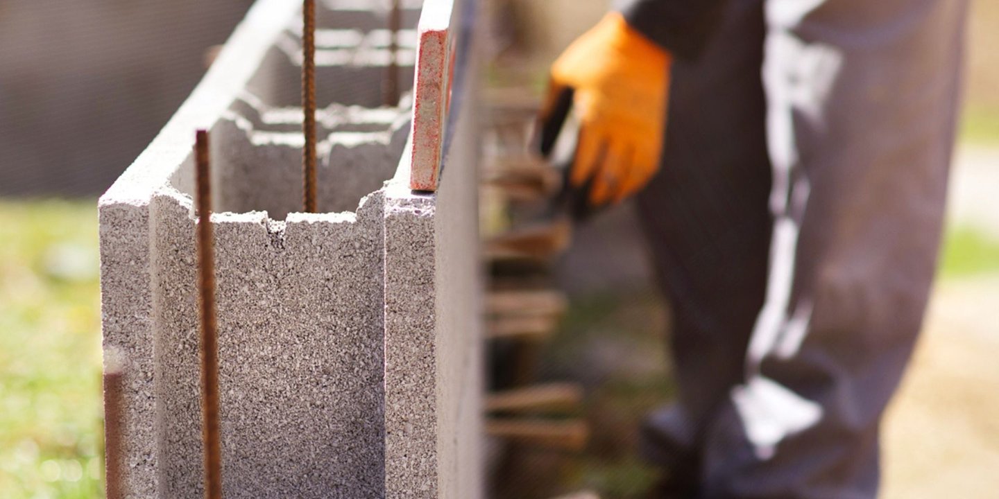 Montering av betongblokker med vater og arbeidshansker