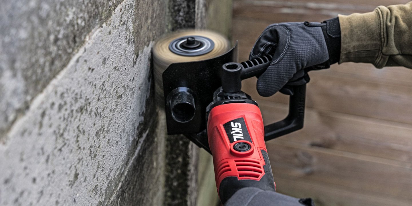 Skil slipemaskin som brukes mot en murvegg