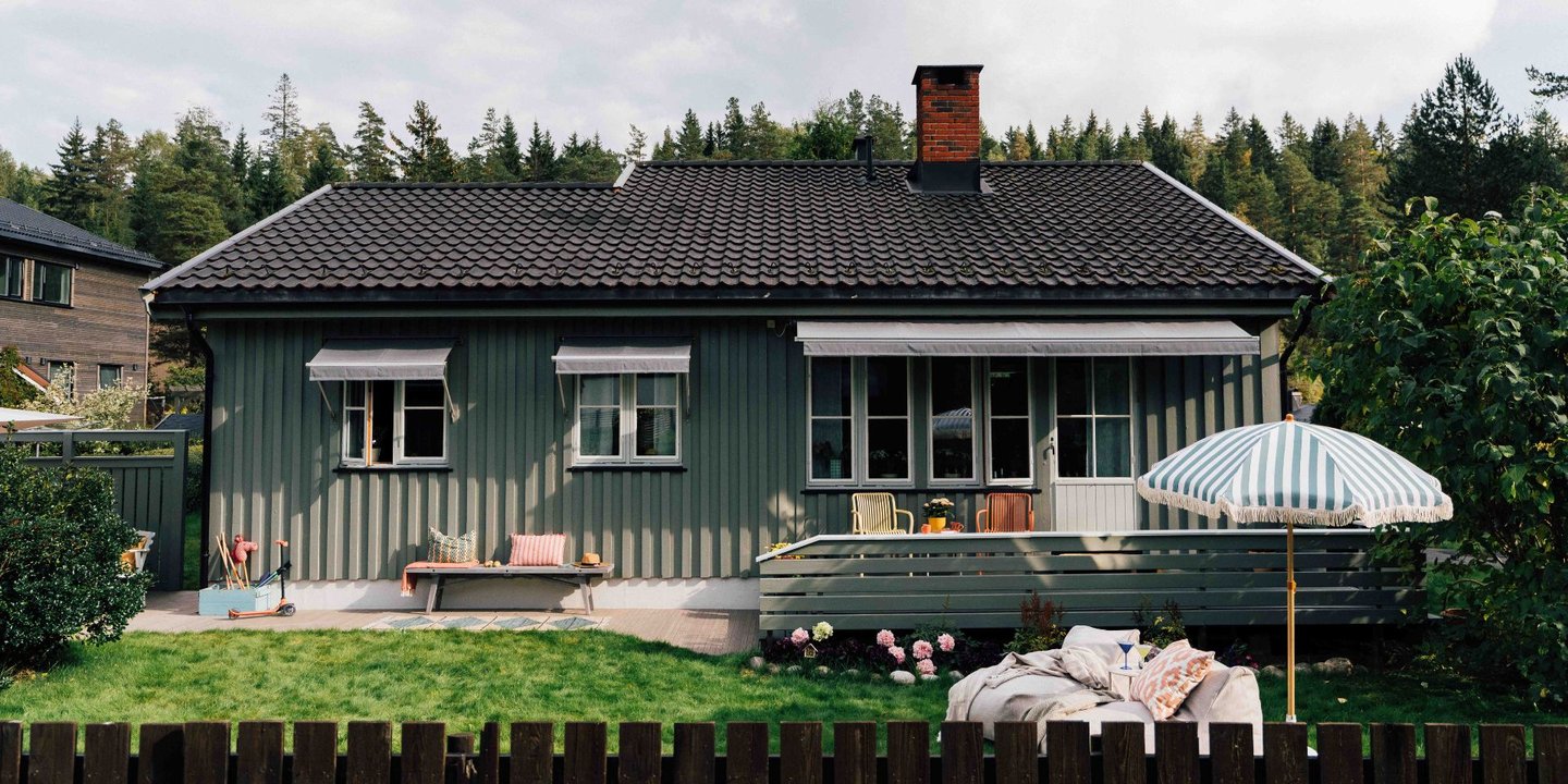 Grønt hus med hage foran huset