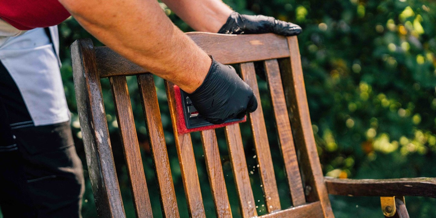 Person pusser utestol av tre