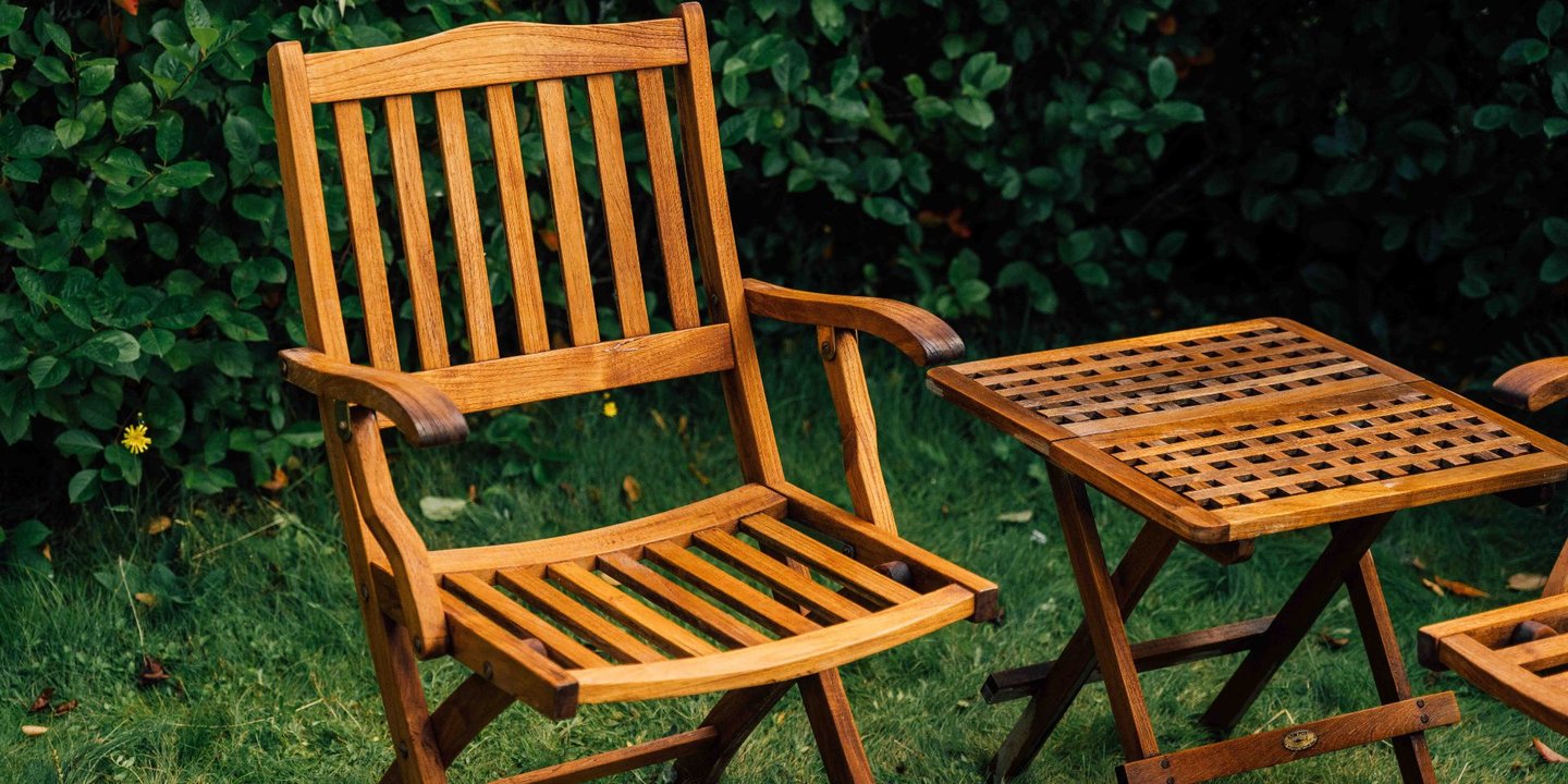 Nyoljet utestol av tre i grønne omgivelser