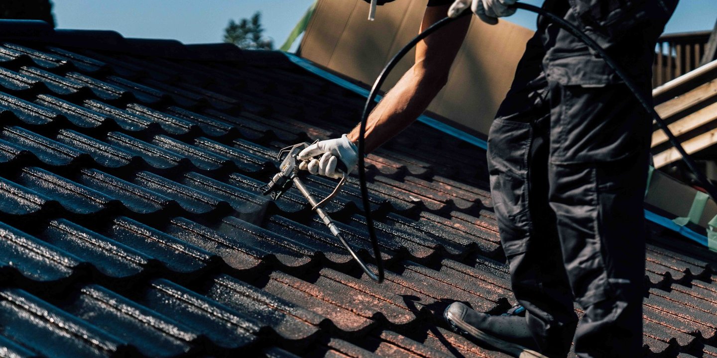 Mann som spraymaler taketstein