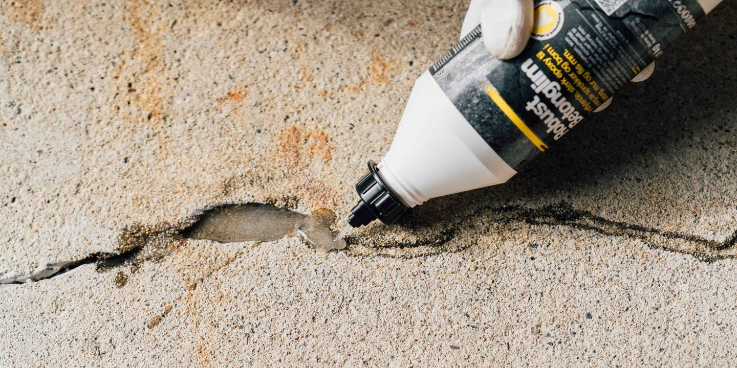 Bilde av en sparkel for grunnmuren. Viser en sprekk som blir sparklet på nært hold.