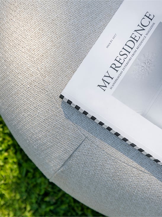 Et magasin ligger på en grå Skagen puff.