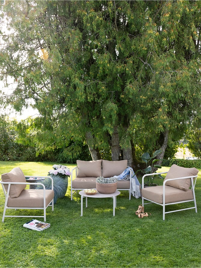 Brevik sofaserie på en gressplen. I modell kalk og terracotta. 