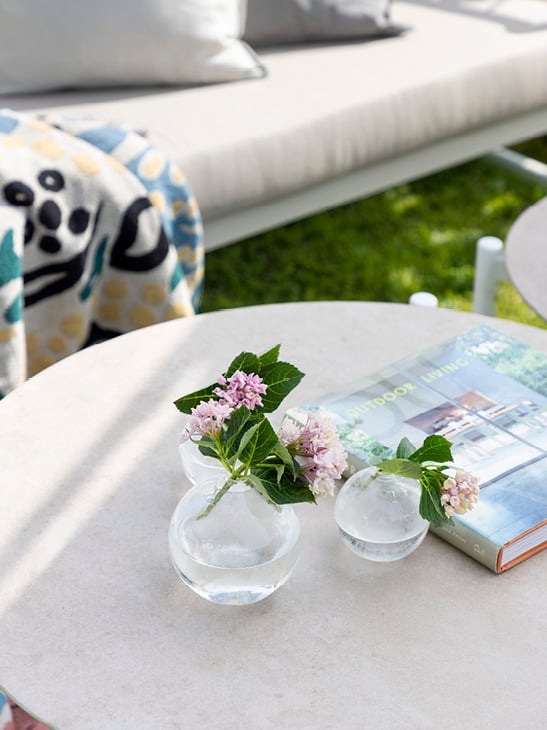 Detaljebilde av et Sandefjord hvitt sofabord med var med blomster i.