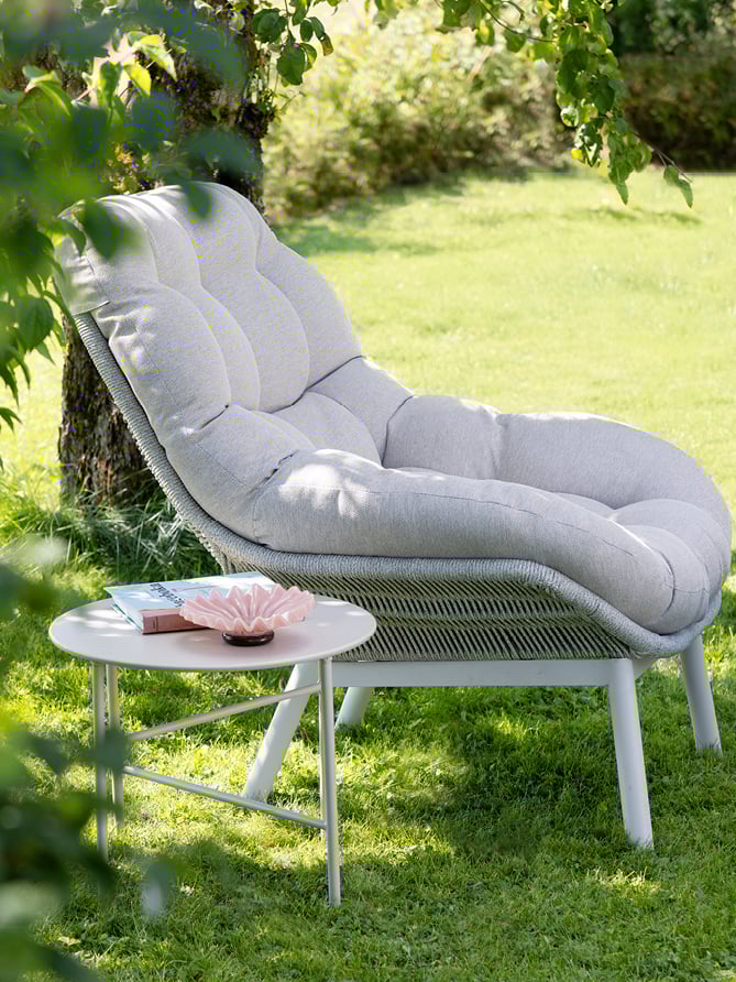 Bohem Risør stol med fotskammel på en gressplen.