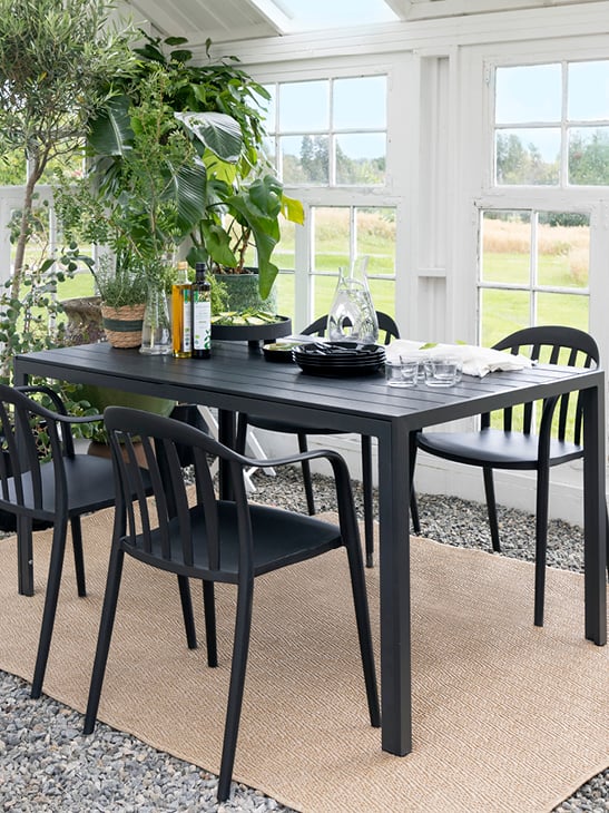 Bohem Vika stol i sort rundt et spisebord i en hagestue.