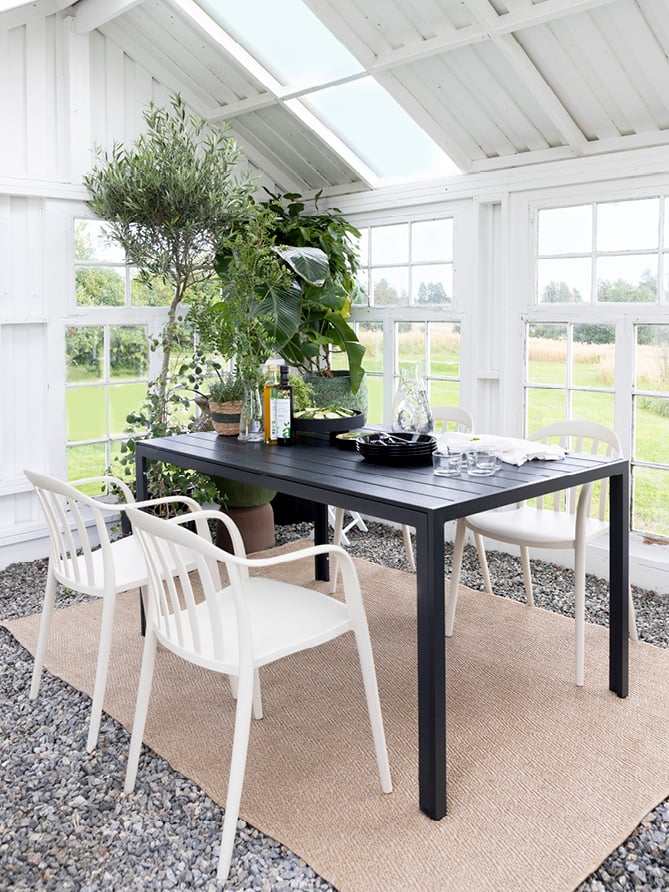 Bohem Vika stol i beige rundt Bohem Nyheim bord i en hagestue.