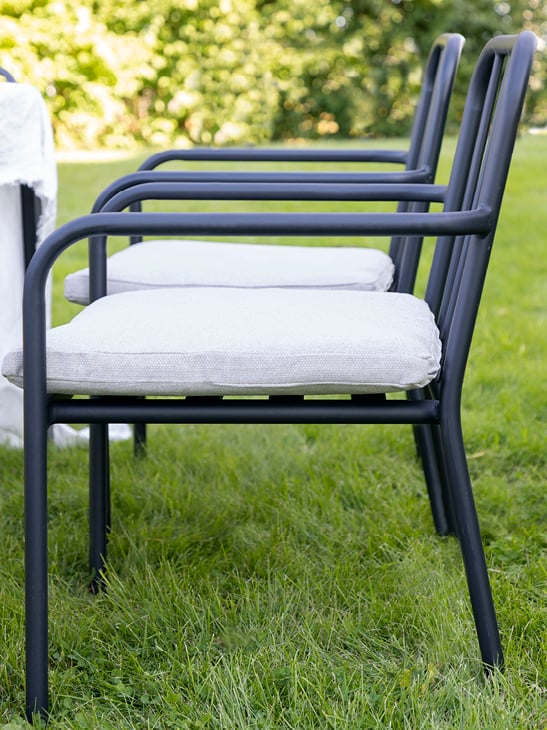 Bohem Brevik stol i sort med pute på en gressplen.