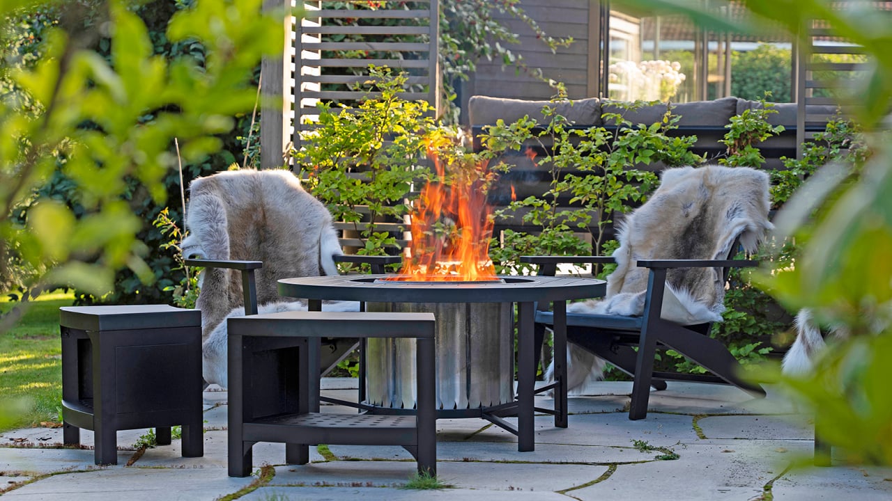 Volcano bord og stoler rundt en Volcano bålpanne med flammer.