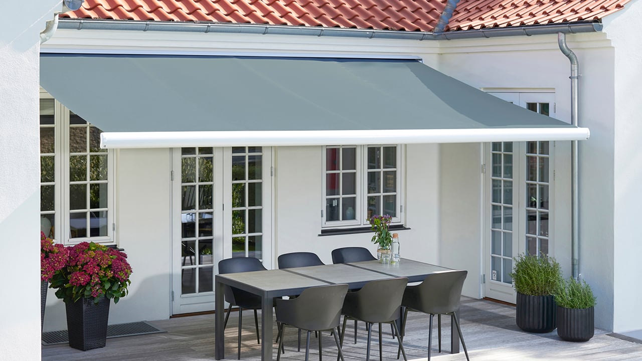 Terrassemarkise helkassett over en terrasse med spisebord.