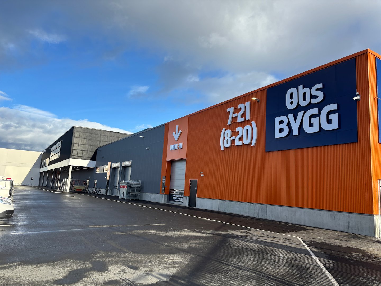 Fasade til Obs BYGG Harstad med blå himmel og sol